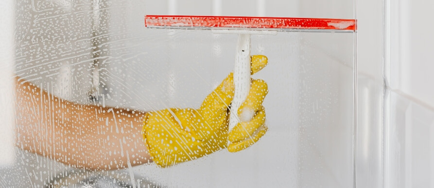 ruka sa žutom gumenom rukavicom i kesom za čišćenje